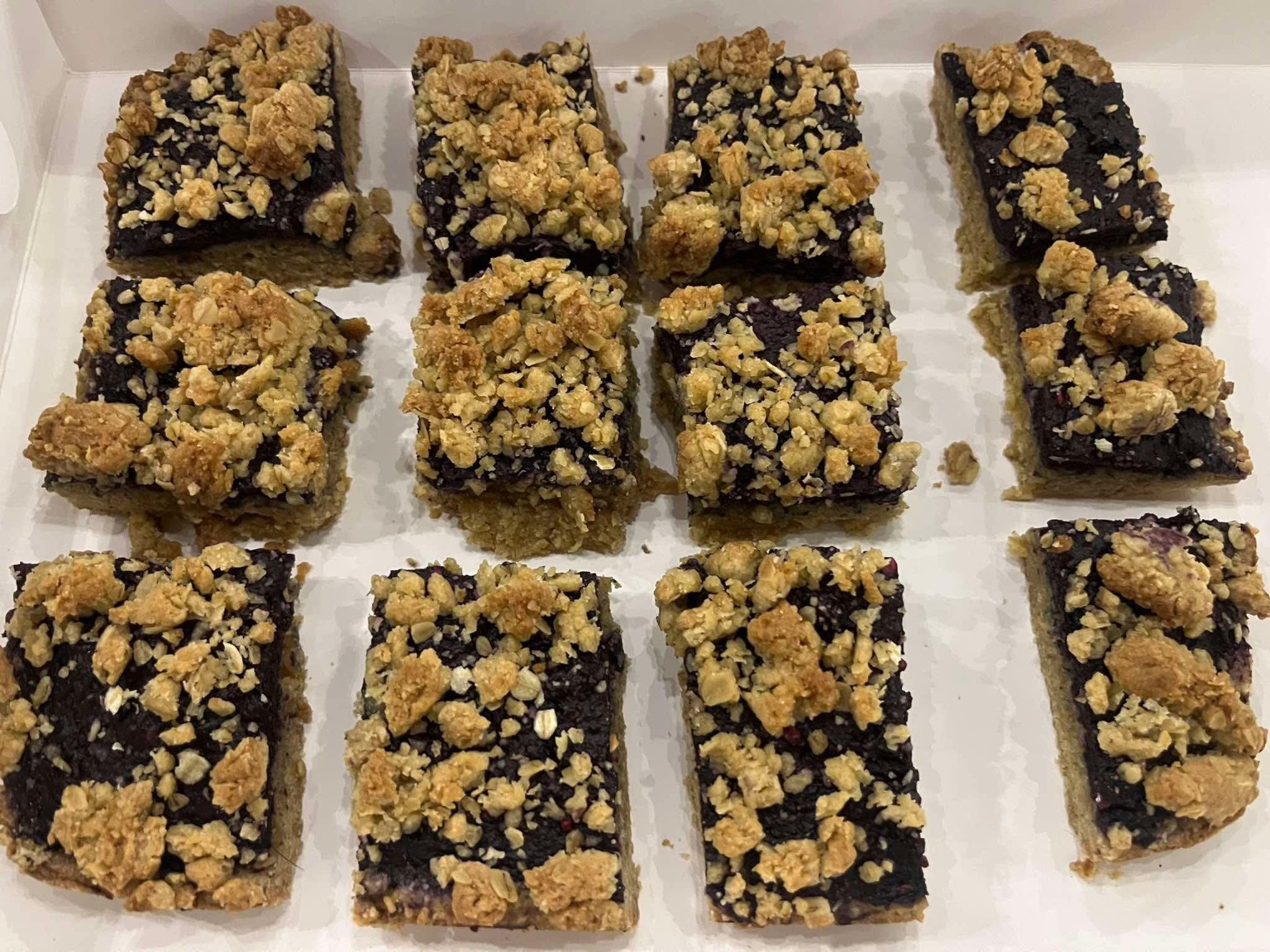 Blueberry oatmeal bars arranged in a bakery box