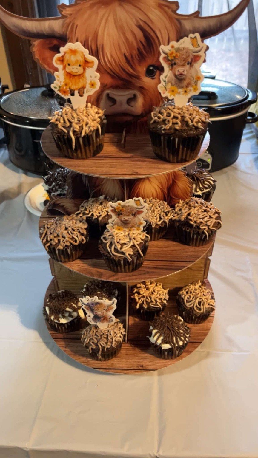 Highland cow themed cupcakes on a tiered display